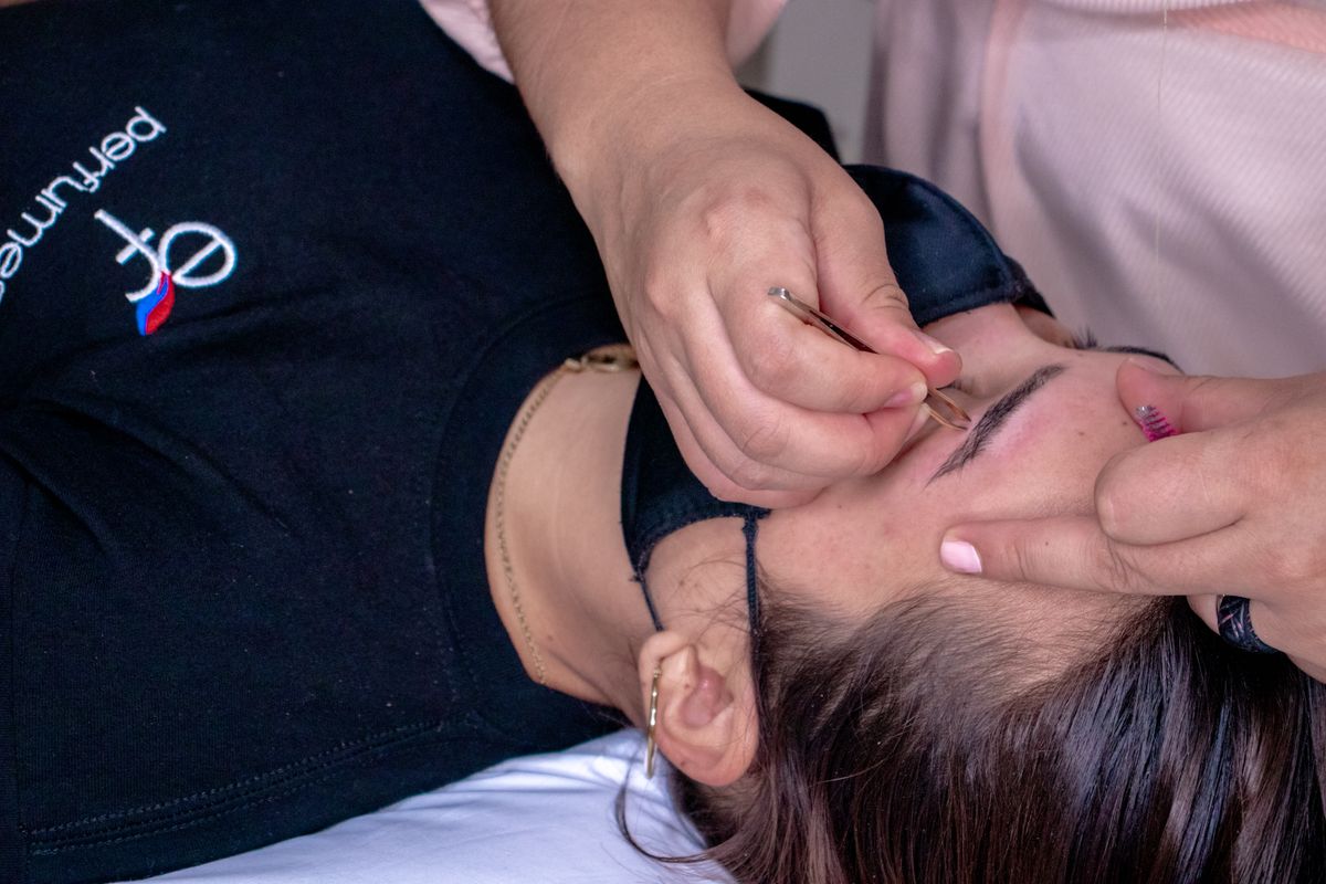 Close-up of a female esthetician styling a client's eyebrows